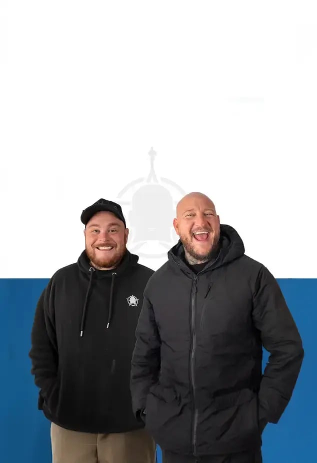 Bald Builders smiling against a blue background 