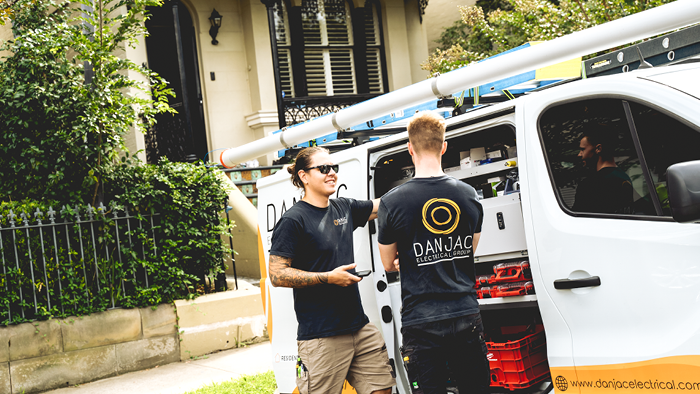 two tradies talking near company vehicle