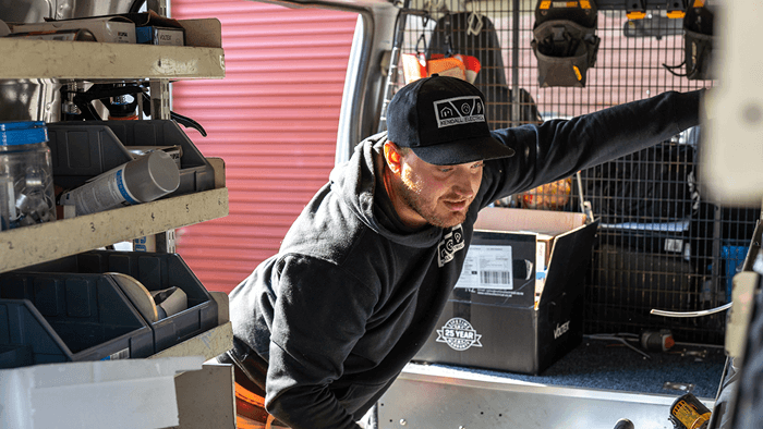 man looking inside work van filled with tools