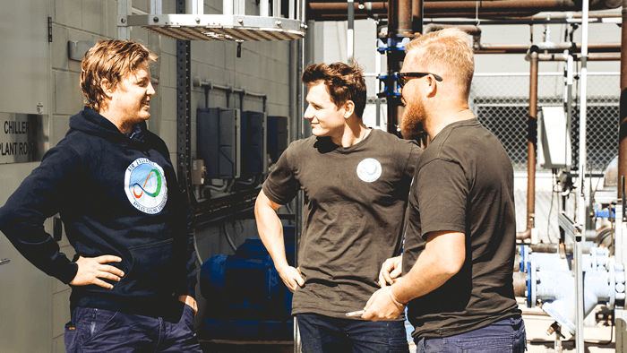 group of young tradies standing around site talking 