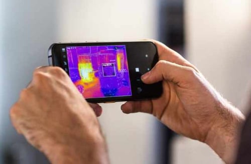 Holding a CAT phone in landscape orientation and using the thermal view feature