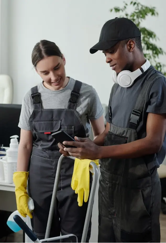 Two cleaners checking a mobile phone