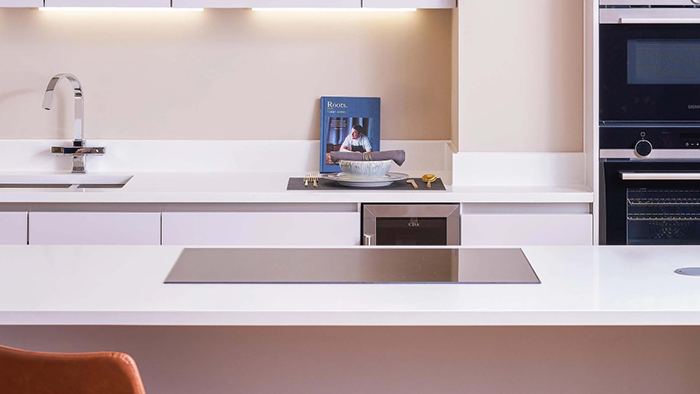 Customer stories_TJaiC Consultancy UK_modern white kitchen with silver taps and black oven and mirowave