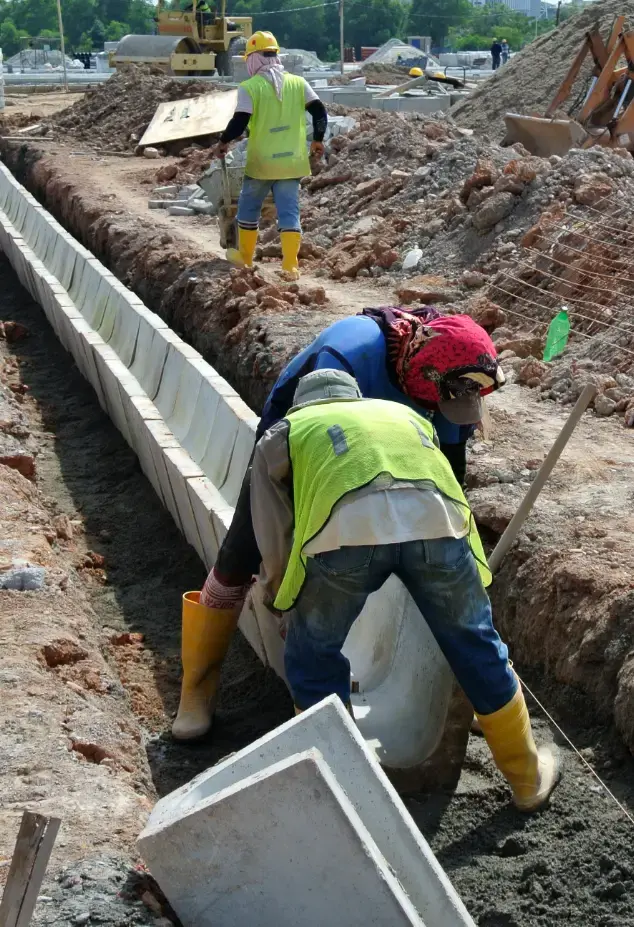 Workers setting a drain into the ground