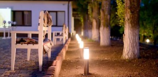 A photo of freshly installed outdoor lighting running along the side of a brick courtyard