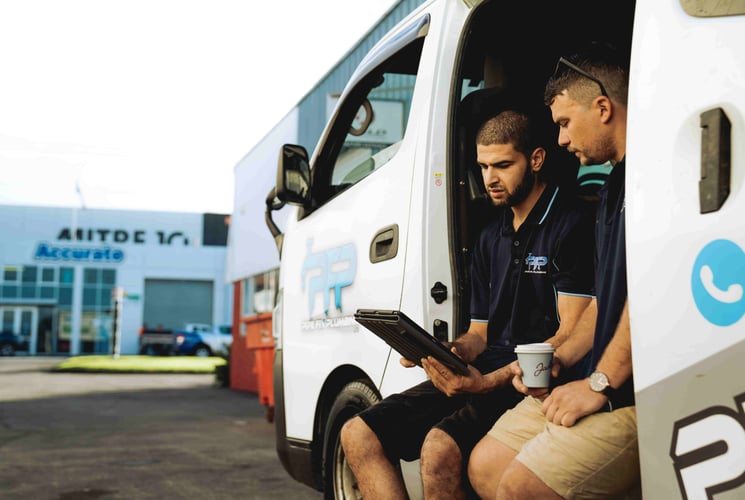 Plumbers conversing over ipad