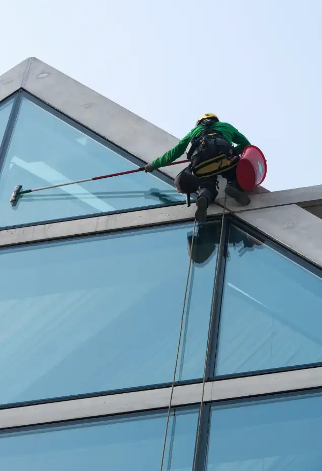 Man in harness cleaning a window