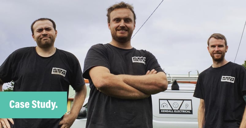 A photo of three electricians from the Kendall Electric team. Each guy wears a black t-shirt with the Kendall Electrical logo.