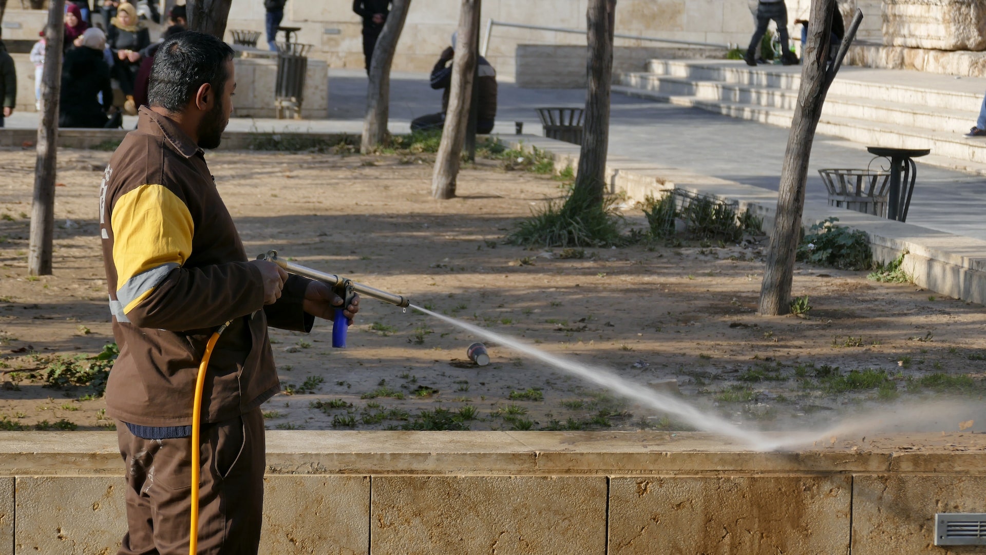 man pressure washing a wall